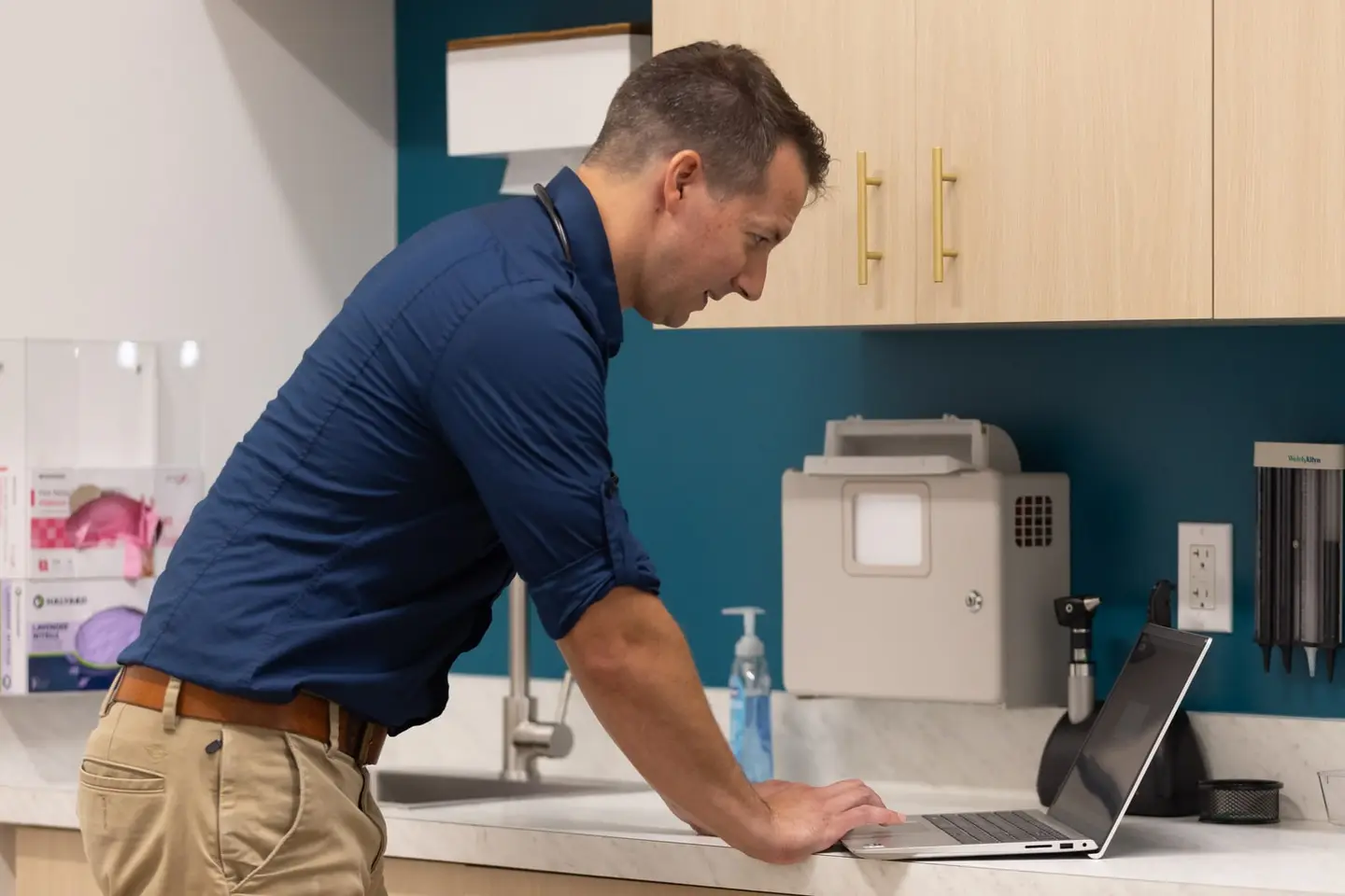 Dr. Nettleman working at a laptop in a FreedomDoc Health exam room